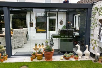Glazen tuinkamer met glazen schuifwanden en buiten keuken in Deurne